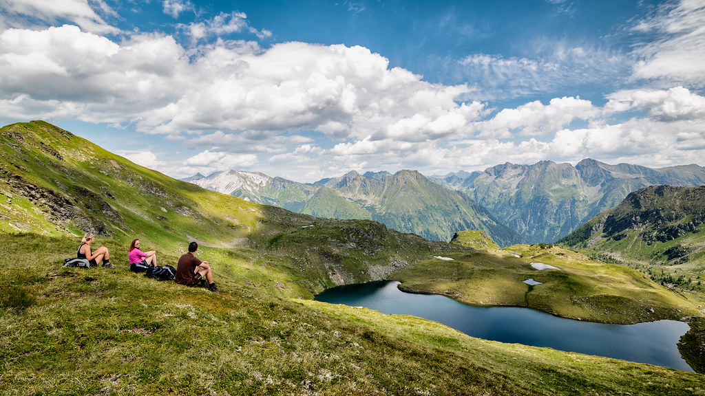 Drei Wander*innen machen Pause am Twenger Almsee