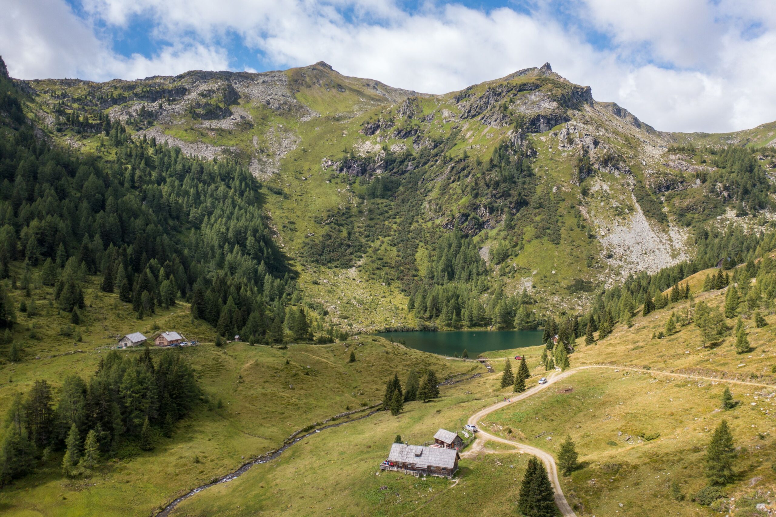 Der Wirpitschsee mit einer Almhütte und den umliegenden Bergen