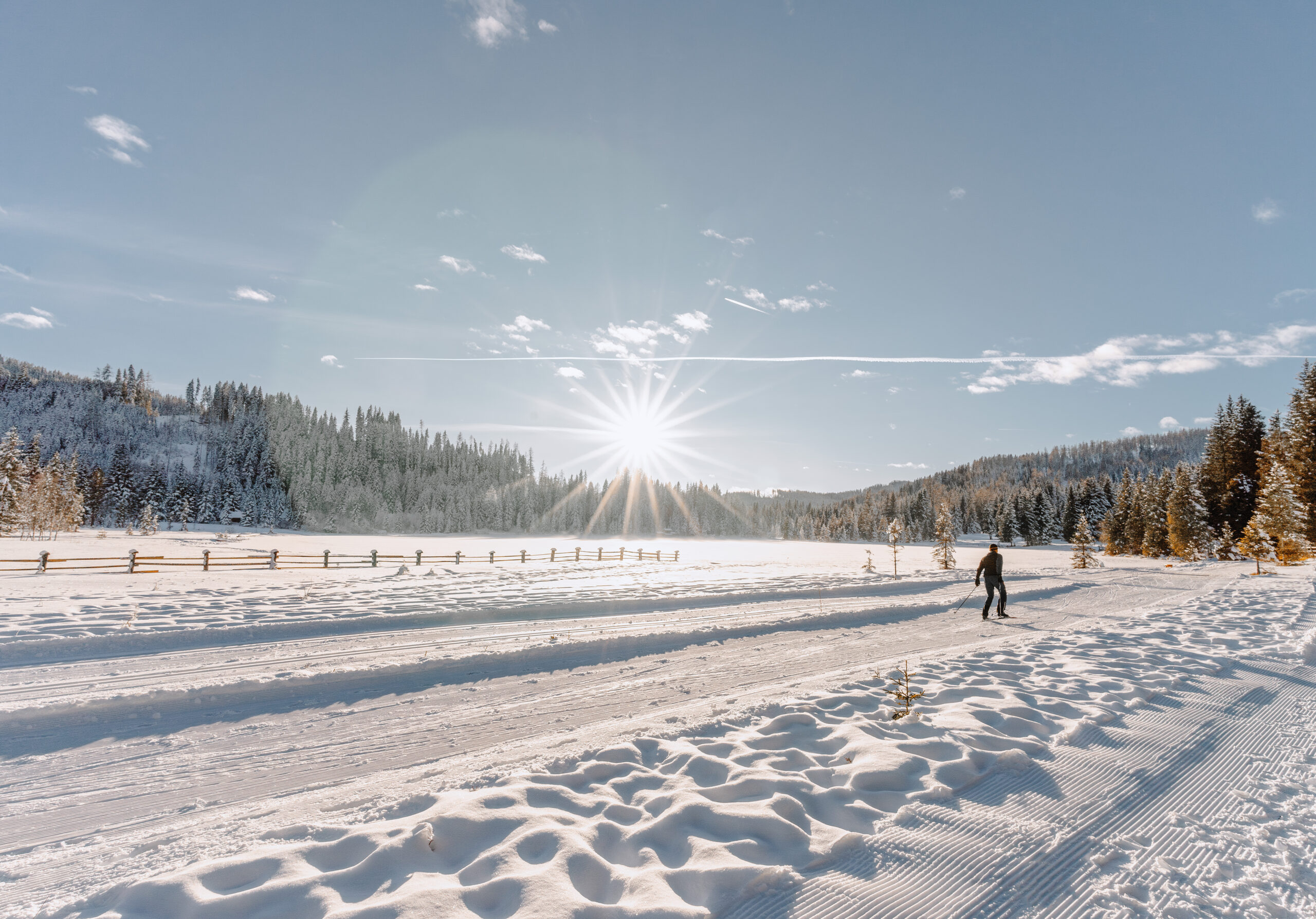 Langlaufloipe mit Naturschnee und blauem Himmel